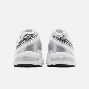 A pair of ASICS Gel-1130 white and silver running shoes with mesh overlays and GEL technology for shock absorption, back view.