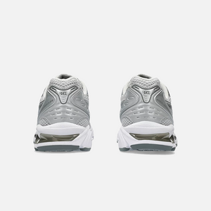 A pair of ASICS Gel-Kayano 14 Cloud Grey running shoes for women, featuring a mesh upper with grey accents and a midsole with GEL technology for cushioning, Back view.