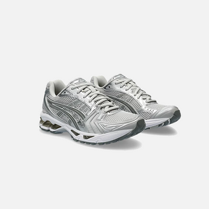 A pair of ASICS Gel-Kayano 14 Cloud Grey running shoes for women, featuring a mesh upper with grey accents and a midsole with GEL technology for cushioning, Side view.