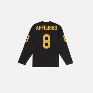 Black long-sleeve shirt with yellow text and numbers on a white background